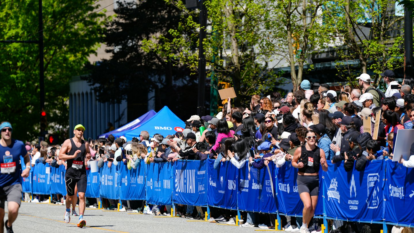 Runners compete on a city street during a marathon.